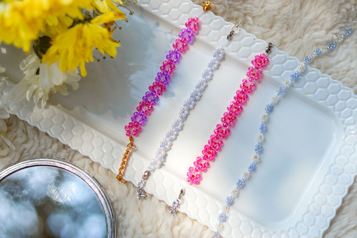 A vivid array of bead bracelets on a white tray with flowers. Perfect for fashion and lifestyle themes.